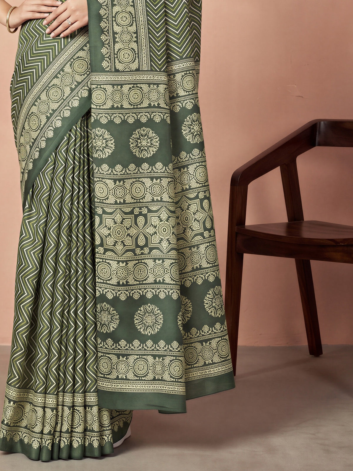Pallu detail of green dola silk saree showing geometric pattern design and printed border