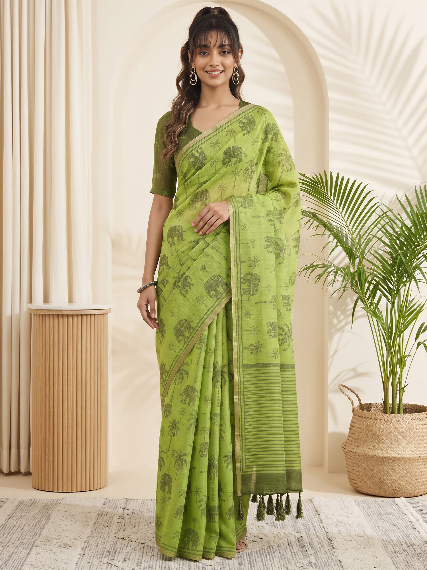 Woman wearing light green cotton linen saree with traditional indian motif work and green blouse