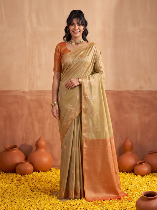 Woman wearing beige tussar silk saree with traditional indian motif work and rust blouse