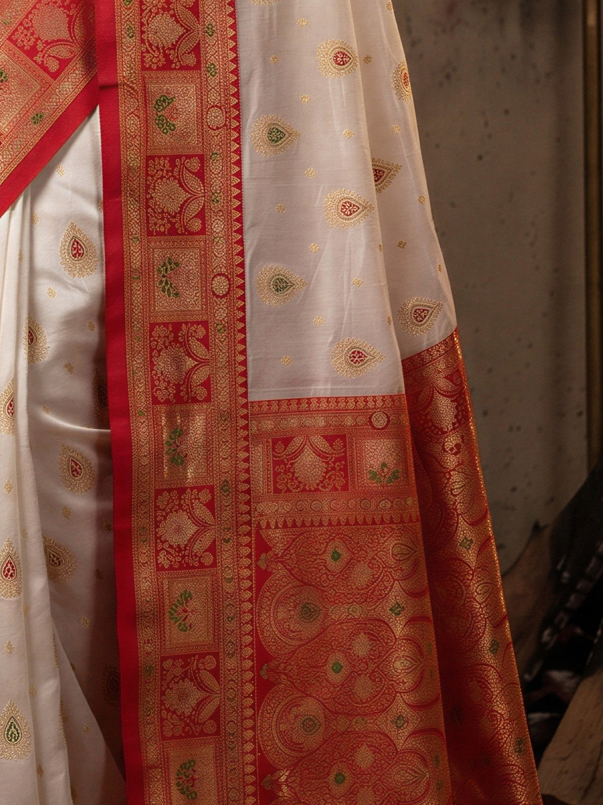 Pallu detail of white banarasi silk saree showing zari butta (metallic motif) work and zari border