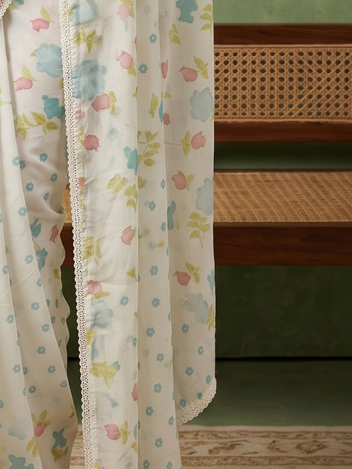 Pallu detail of off white georgette saree showing all-over floral design and embroidered border