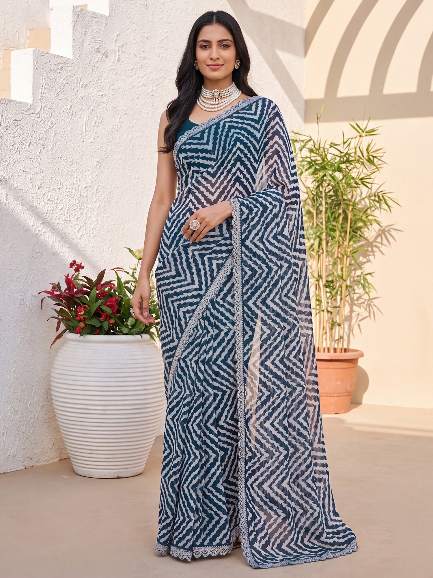 Woman wearing teal blue georgette saree with geometric pattern design and teal blue blouse