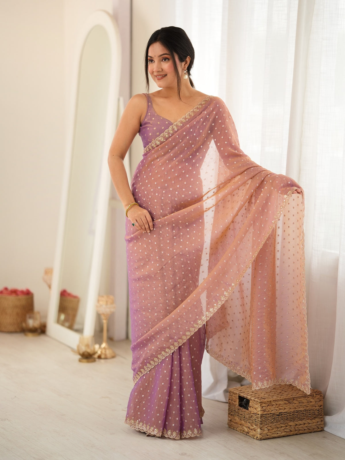 Woman wearing rose gold georgette saree with zari butta (metallic motif) work and rose gold blouse