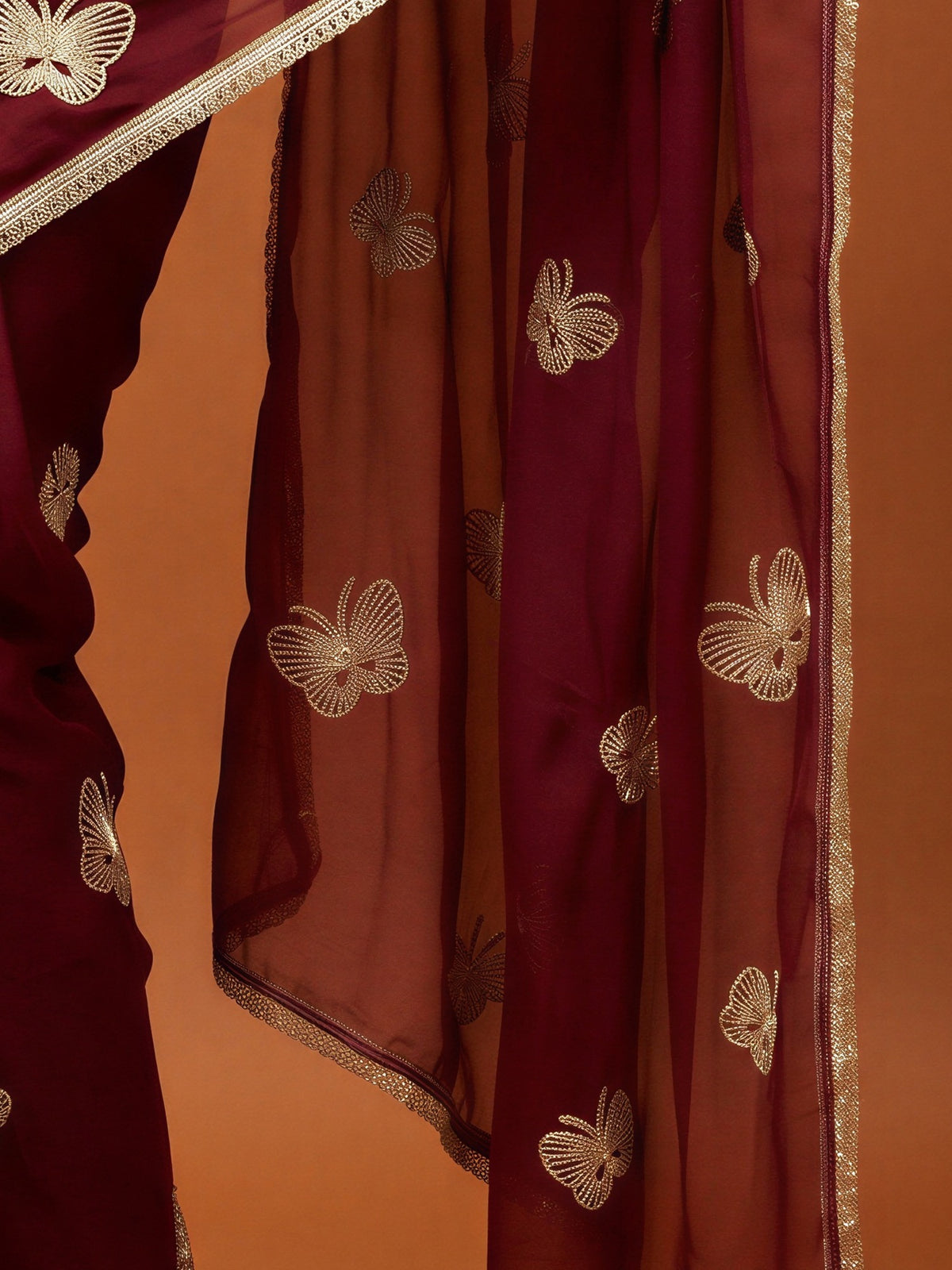 Pallu detail of maroon georgette saree showing embroidered motif work and embellished border