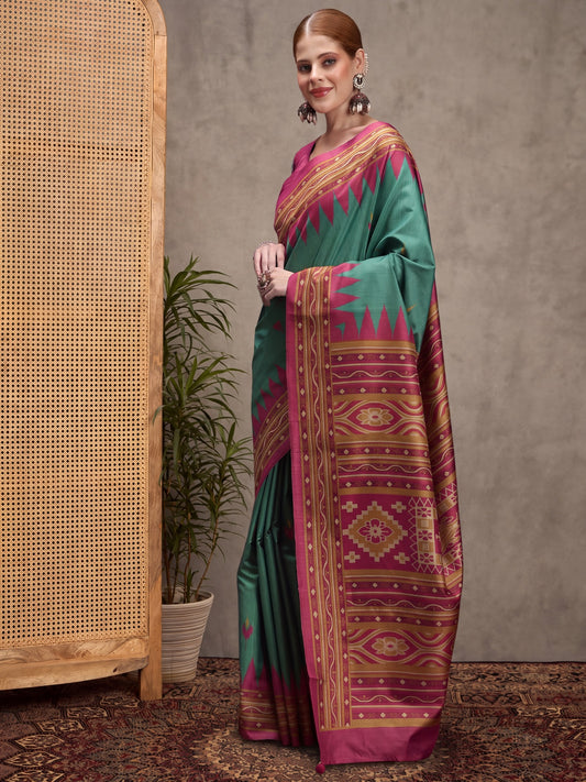 Woman wearing teal green silk blend saree with traditional indian motif work and magenta blouse