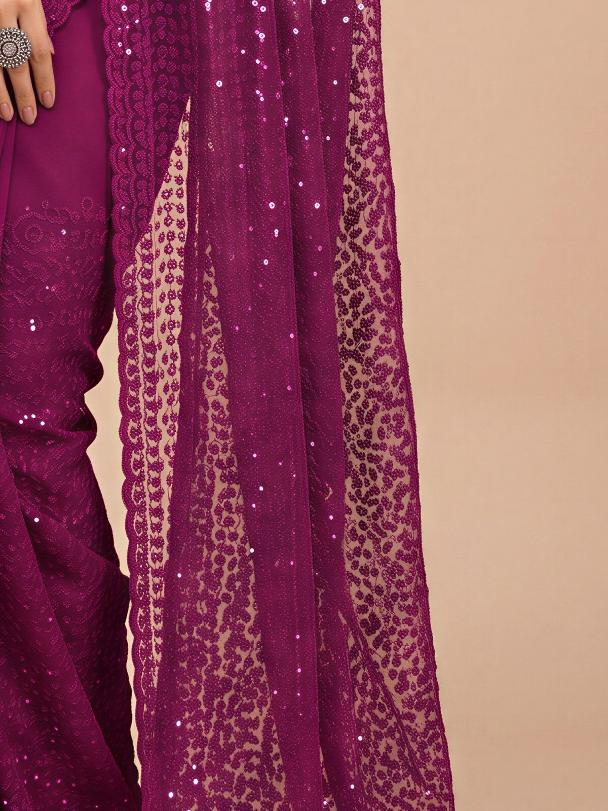 Pallu detail of black net saree showing embroidered motif work and embellished border