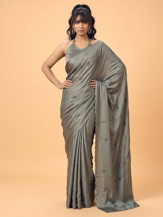 Woman wearing olive satin silk saree with ornamented surface design and olive blouse