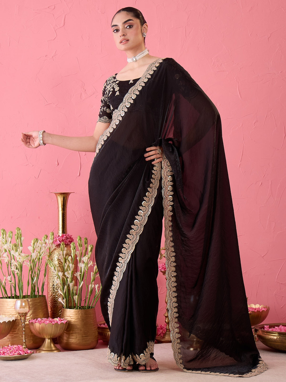 Woman wearing black satin ready to wear saree with ornamented surface design and black blouse