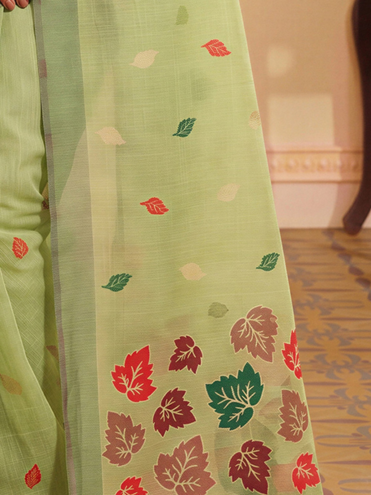 Pallu detail of lime green silk blend saree showing zari butta (metallic motif) work and zari border
