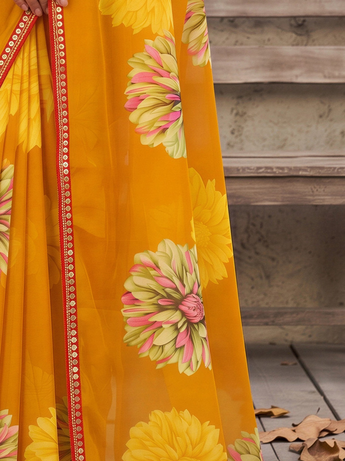 Pallu detail of mustard georgette saree showing all-over floral design and embellished border