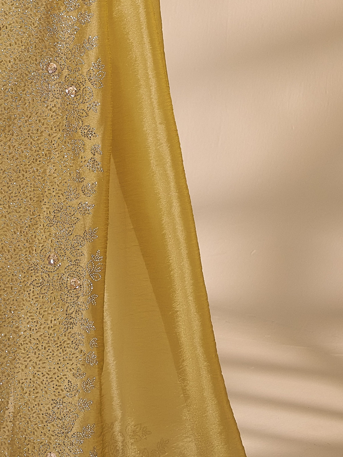 Pallu detail of yellow organza saree showing applique design and embellished border