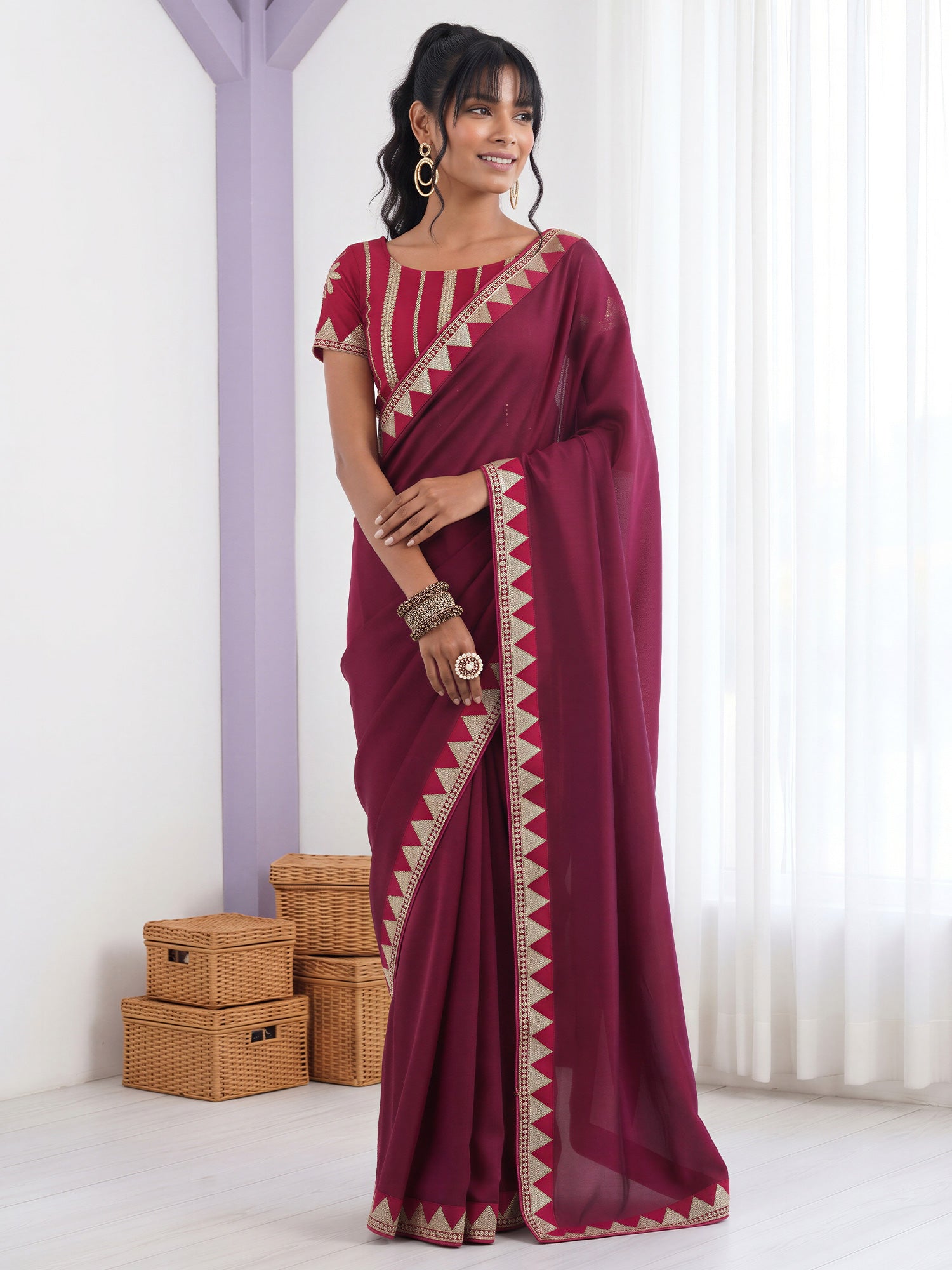 Woman wearing purple vichitra silk saree with embroidered motif work and pink blouse