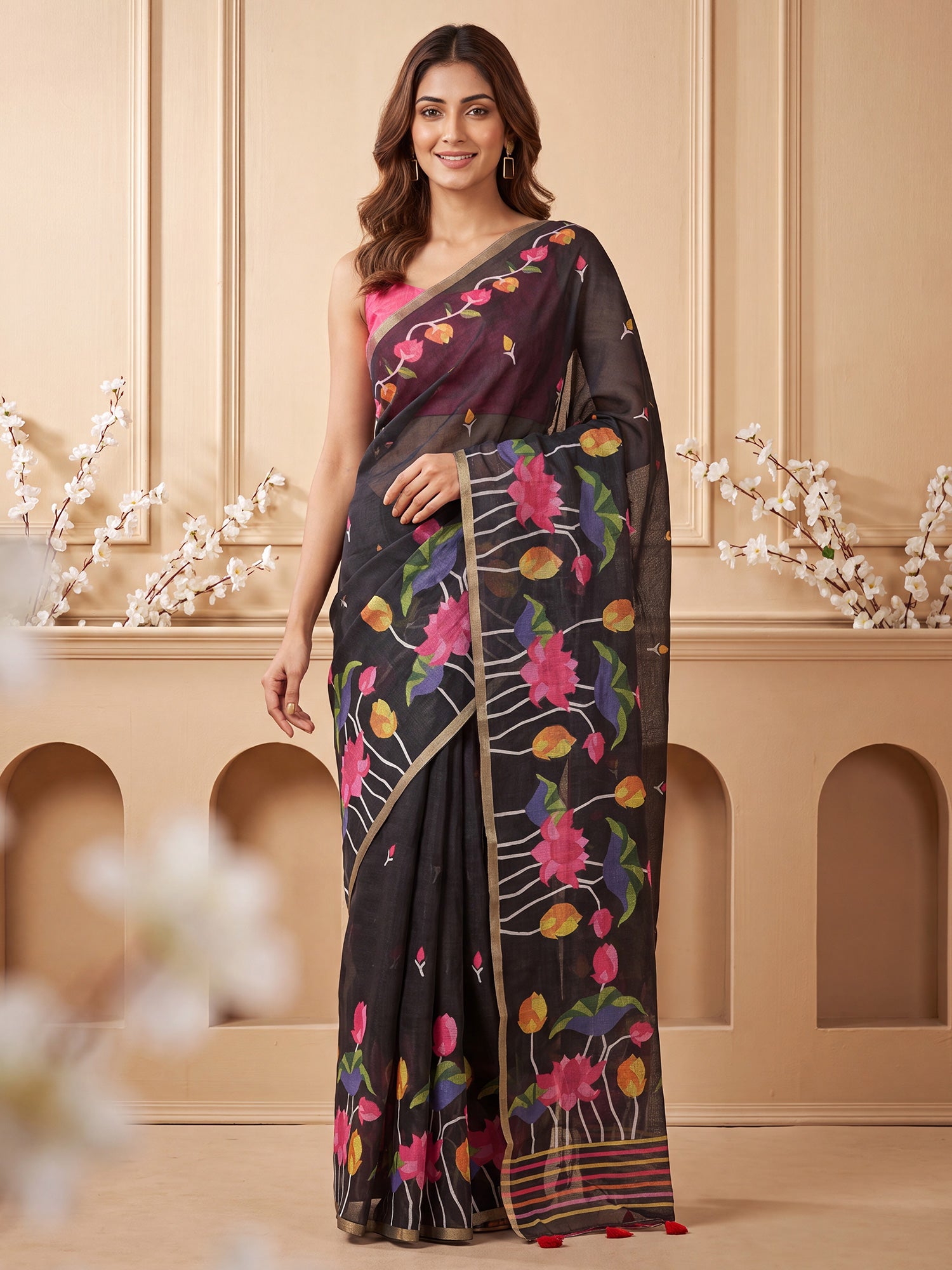 Woman wearing black cotton linen saree with botanical floral and leaf design and pink blouse
