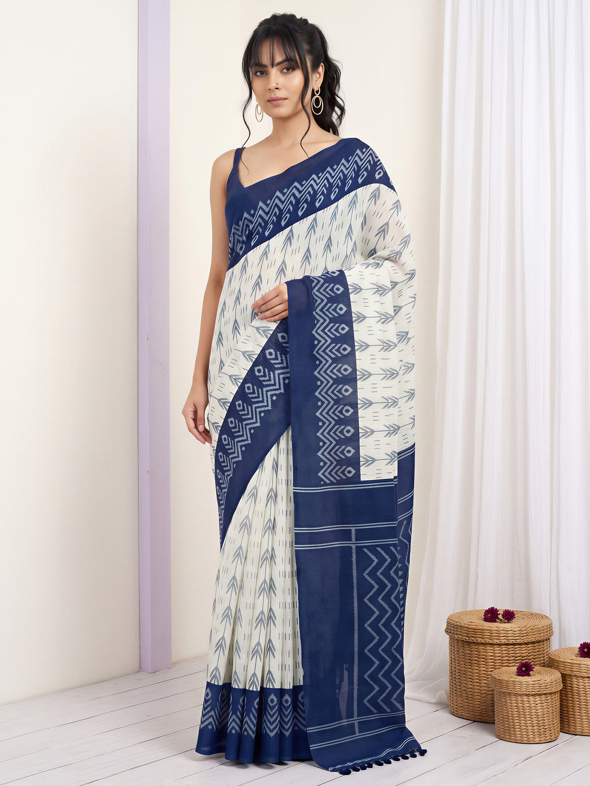 Woman wearing off white cotton blend saree with traditional indian motif work and navy blue blouse