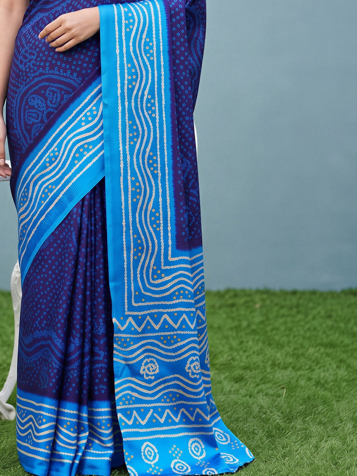 Pallu detail of navy blue satin silk saree showing bandhani tie-dye dot work and printed border