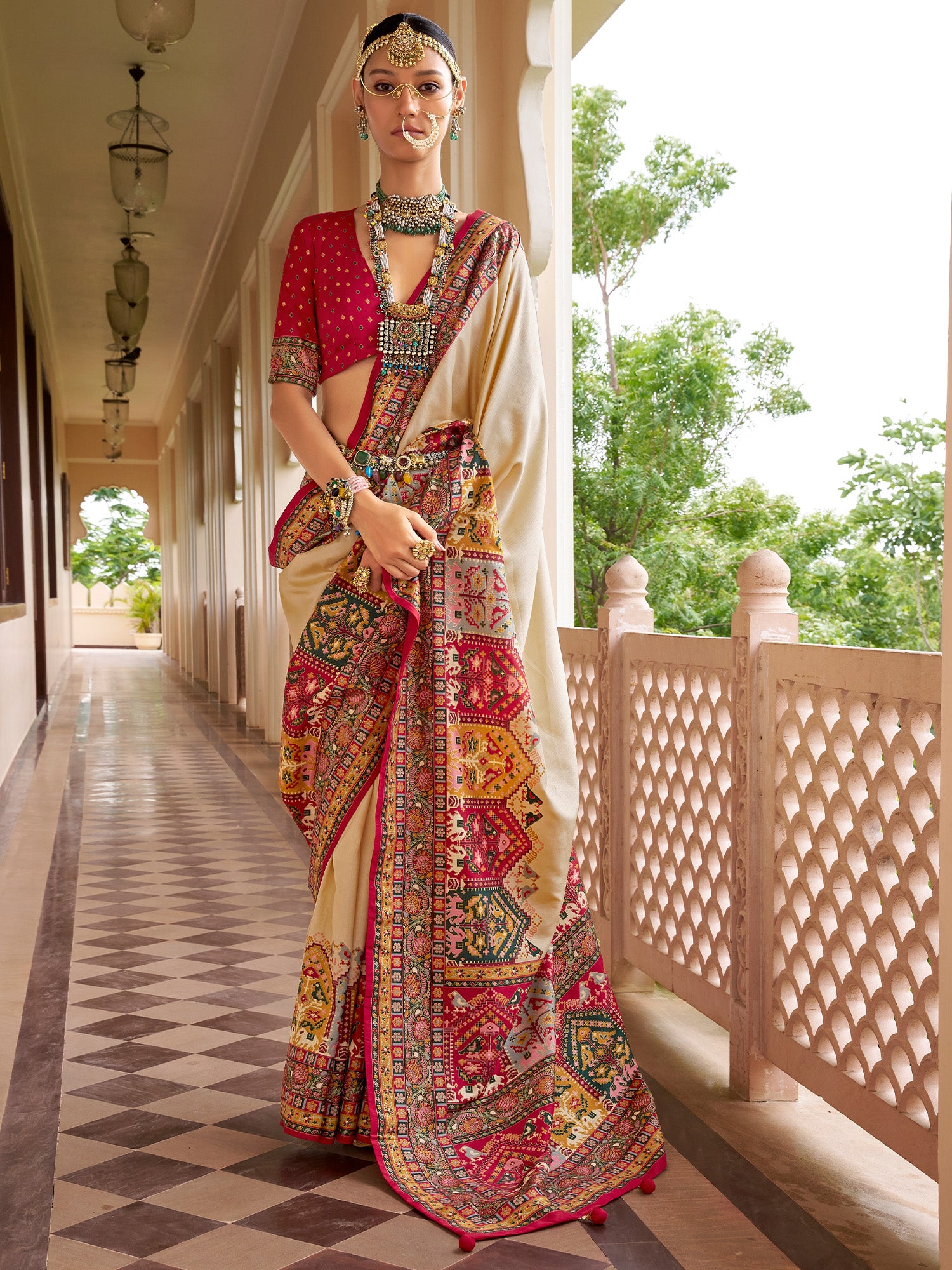 Woman wearing beige silk blend saree with traditional indian motif work and red blouse