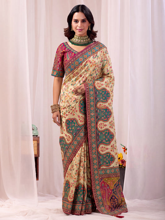 Woman wearing cream silk blend saree with traditional indian motif work and pink blouse