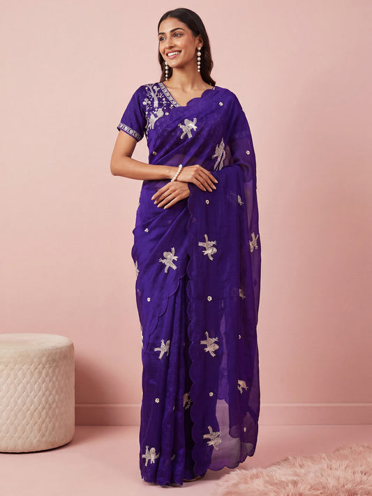 Woman wearing purple satin saree with ornamented surface design and purple blouse