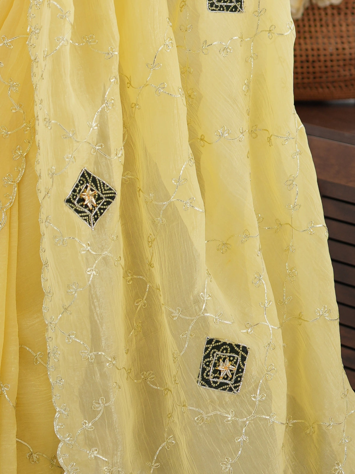 Pallu detail of yellow paper silk saree showing ornamented surface design and embellished border