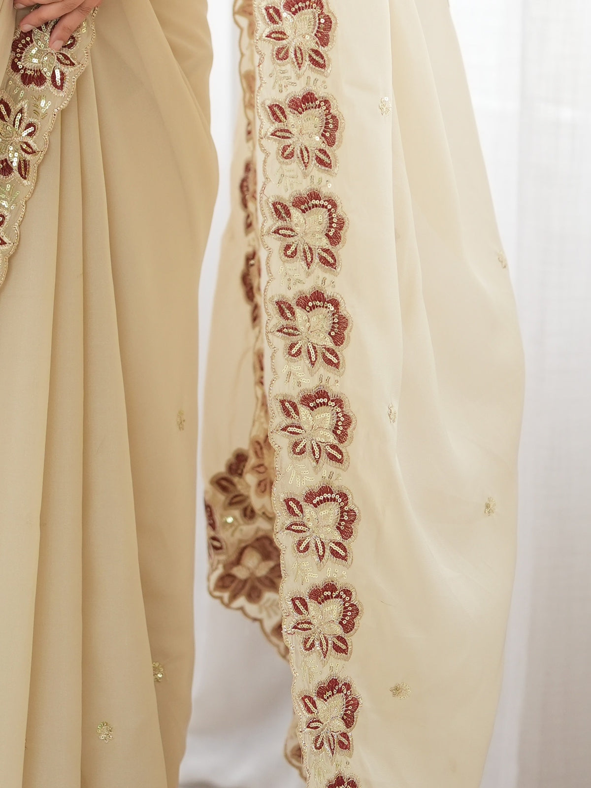 Pallu detail of off white georgette saree showing ornamented surface design and embellished border