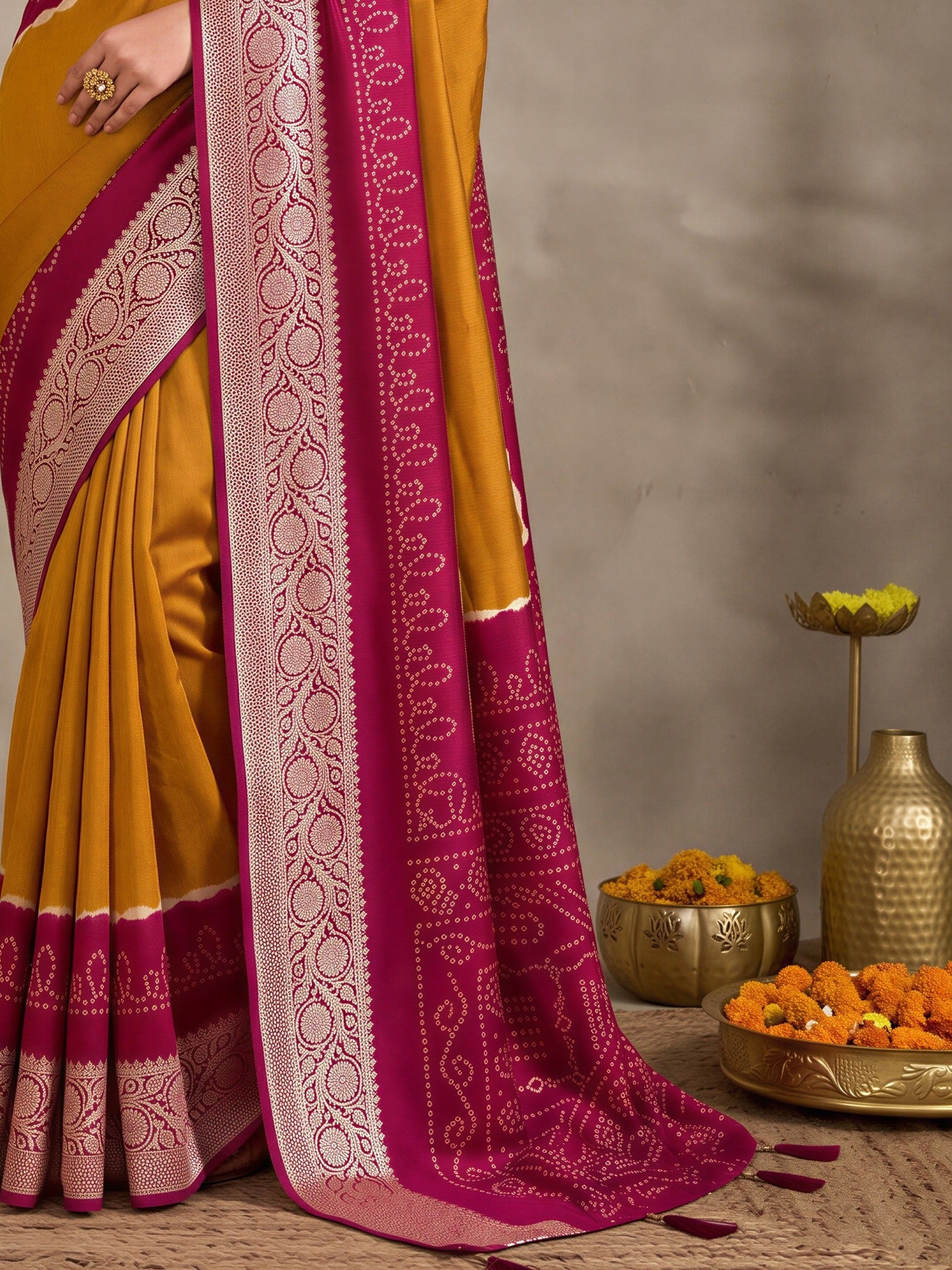 Pallu detail of mustard tussar silk saree showing bandhani tie-dye dot work and woven design border