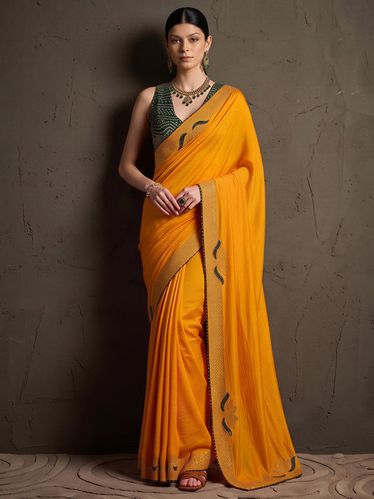 Woman wearing yellow vichitra silk saree with ornamented surface design and green blouse