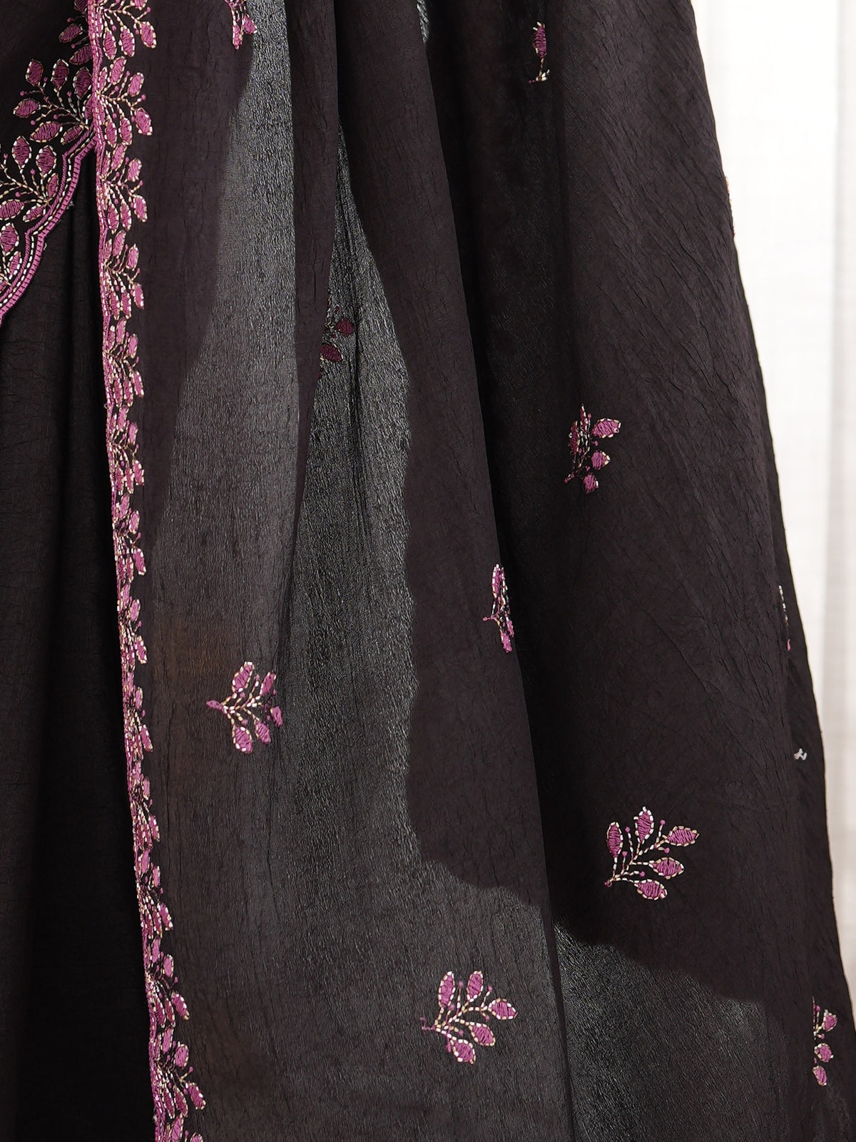 Pallu detail of black poly georgette saree showing ornamented surface design and embellished border