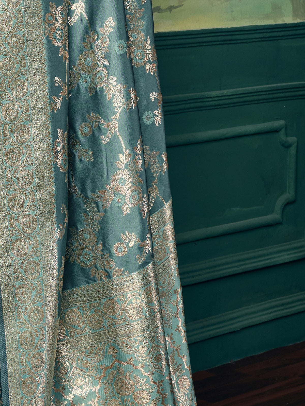 Pallu detail of teal blue banarasi silk saree showing woven motif design and zari border