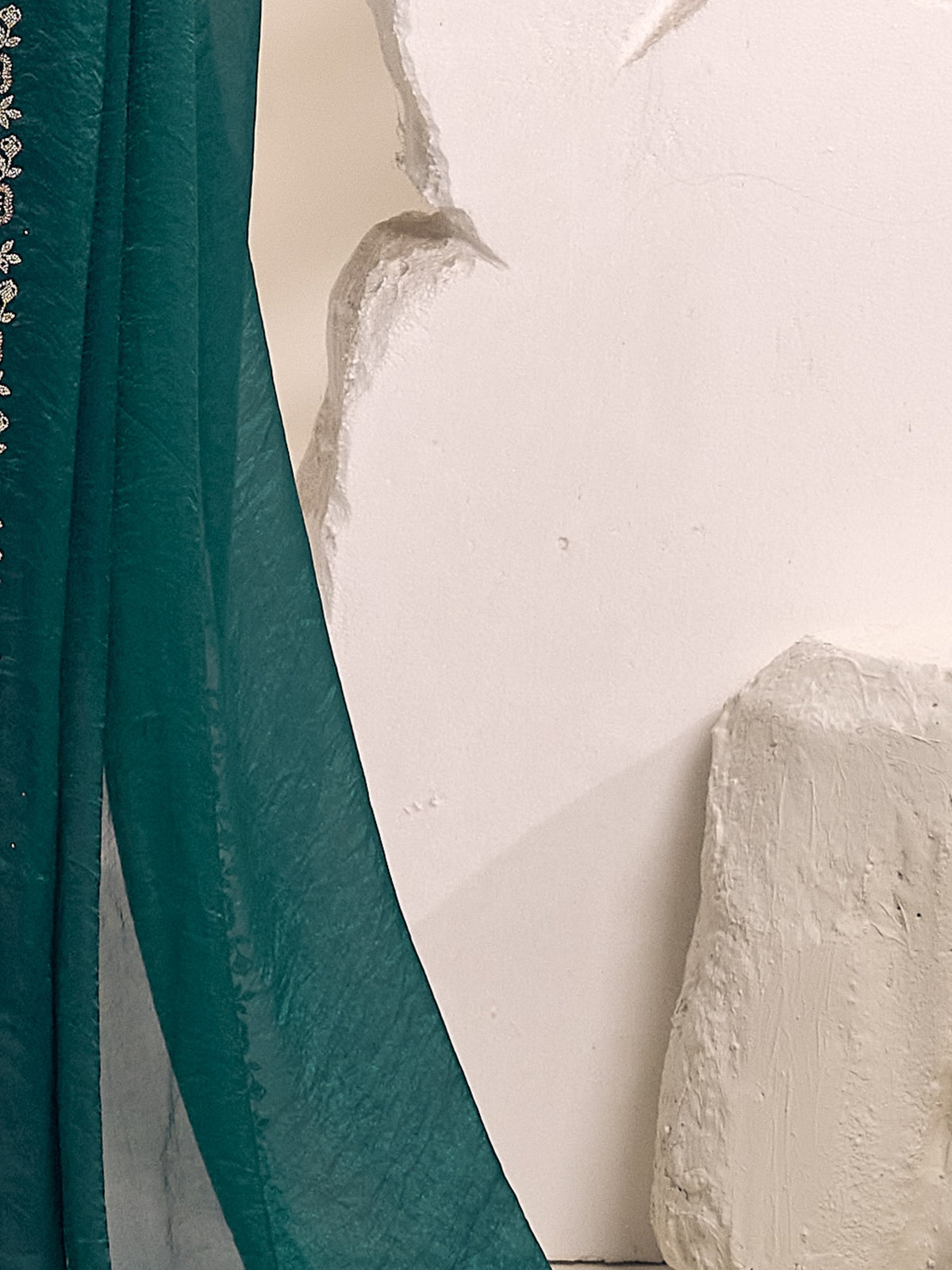 Pallu detail of teal green satin silk saree showing clean solid-tone finish and embellished border
