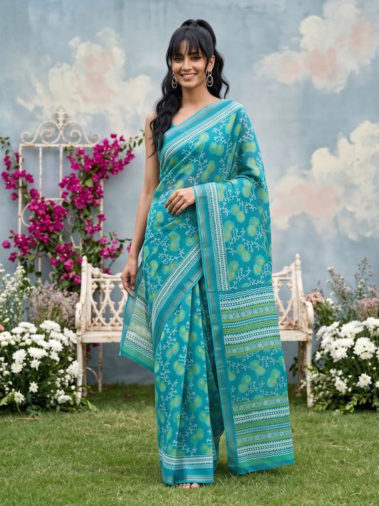 Woman wearing teal blue crepe saree with botanical floral and leaf design and teal blue blouse