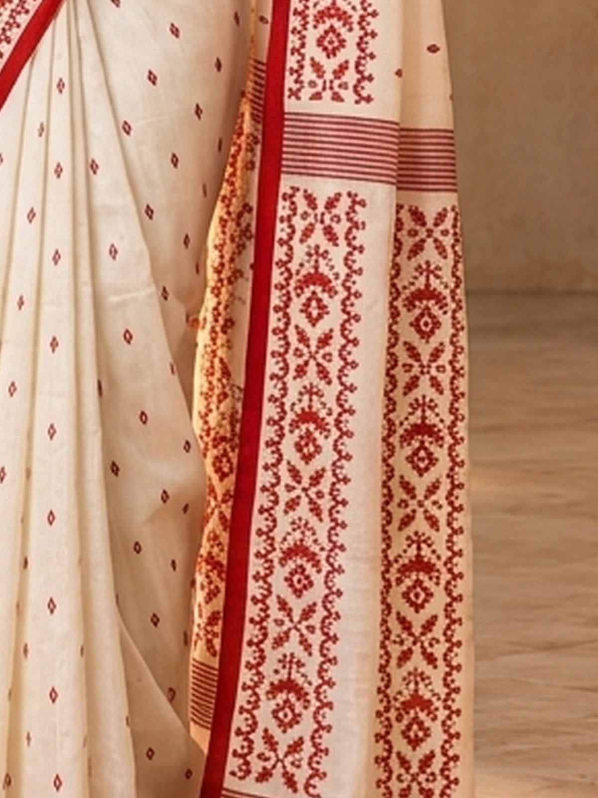 Pallu detail of off white tussar silk saree showing traditional indian motif work and printed border