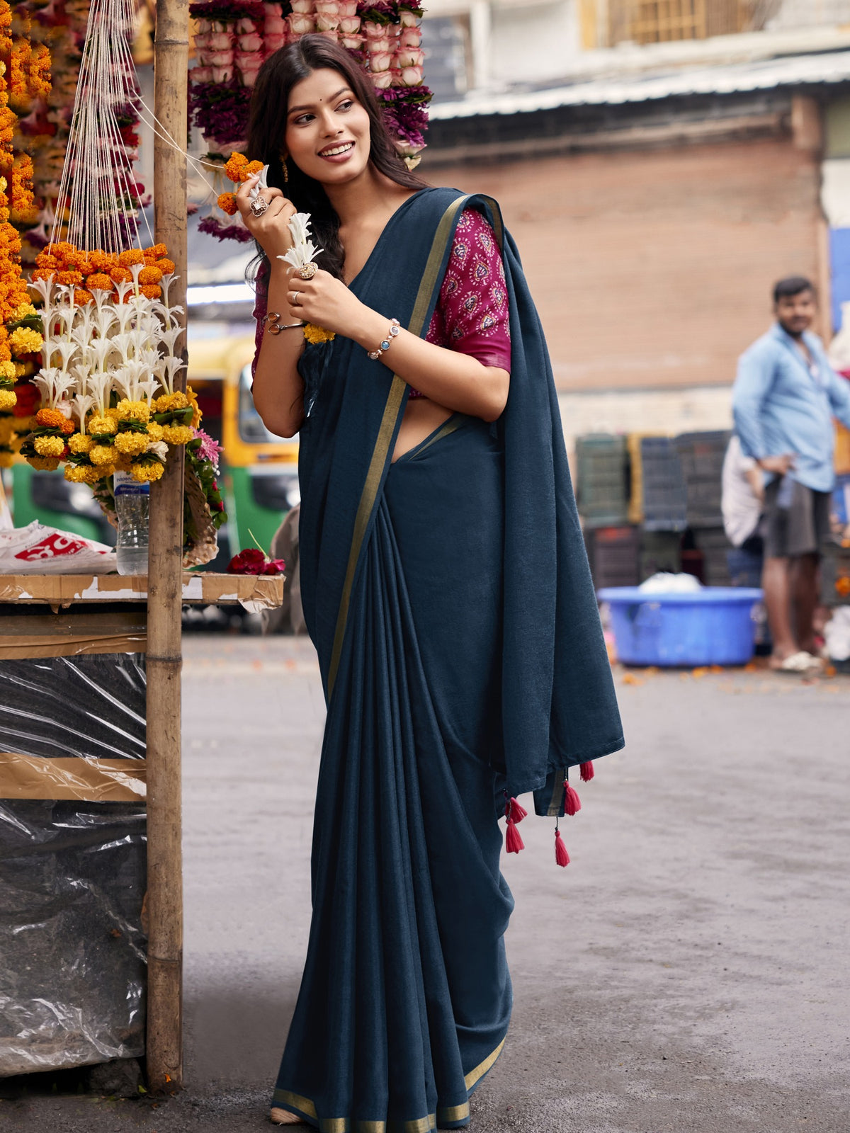 Woman wearing teal blue cotton blend saree with clean solid-tone finish and pink blouse