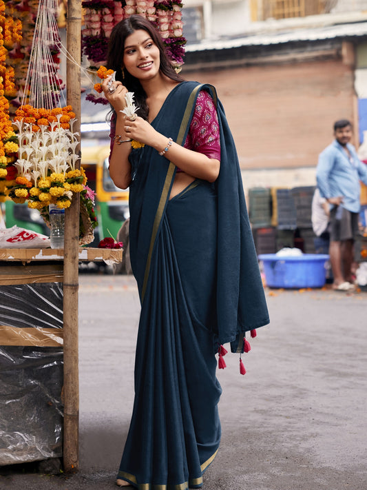 Woman wearing teal blue cotton blend saree with clean solid-tone finish and pink blouse