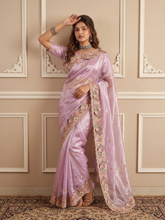 Woman wearing lavender organza saree with ornamented surface design and lavender blouse