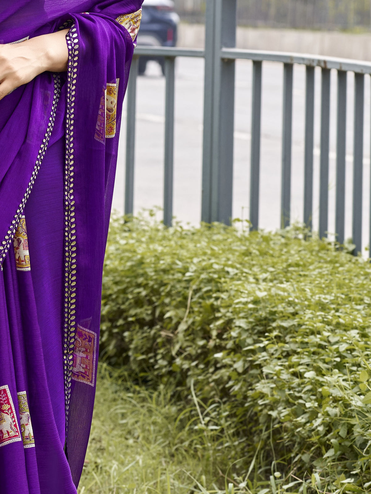 Pallu detail of violet chiffon saree showing metallic foil print work and embellished border