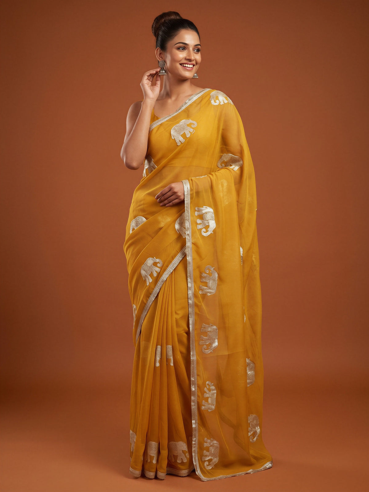 Woman wearing mustard georgette saree with embroidered motif work and mustard blouse