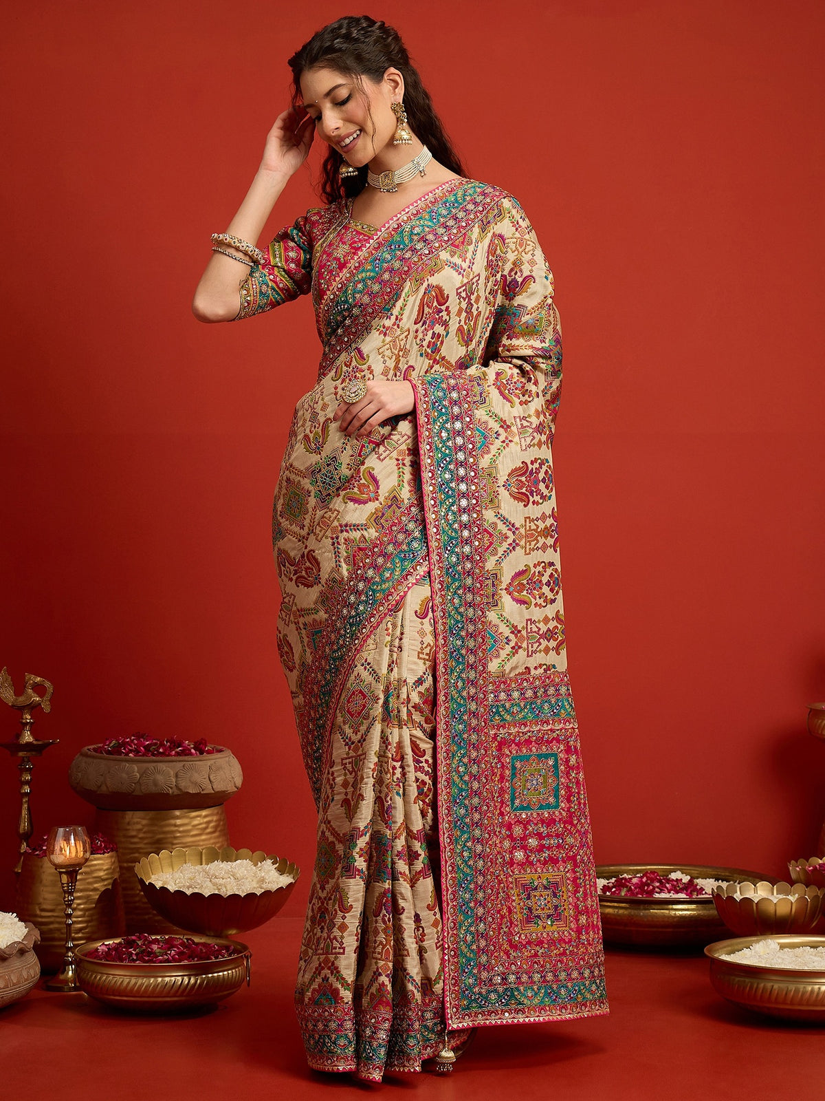 Woman wearing cream silk blend saree with traditional indian motif work and pink blouse