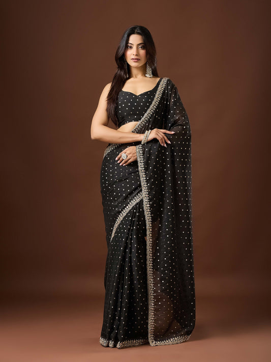 Woman wearing black georgette saree with ornamented surface design and black blouse