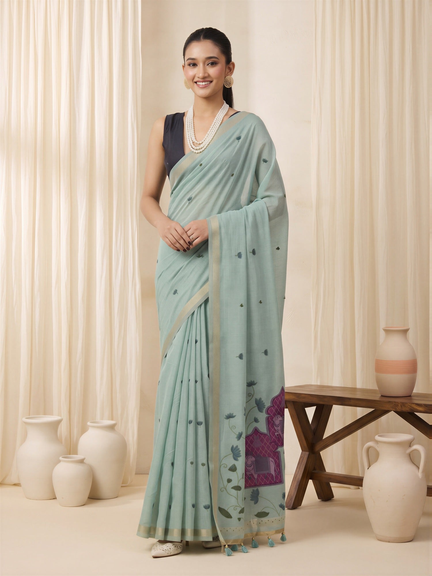 Woman wearing teal blue pure cotton saree with traditional indian motif work and black blouse