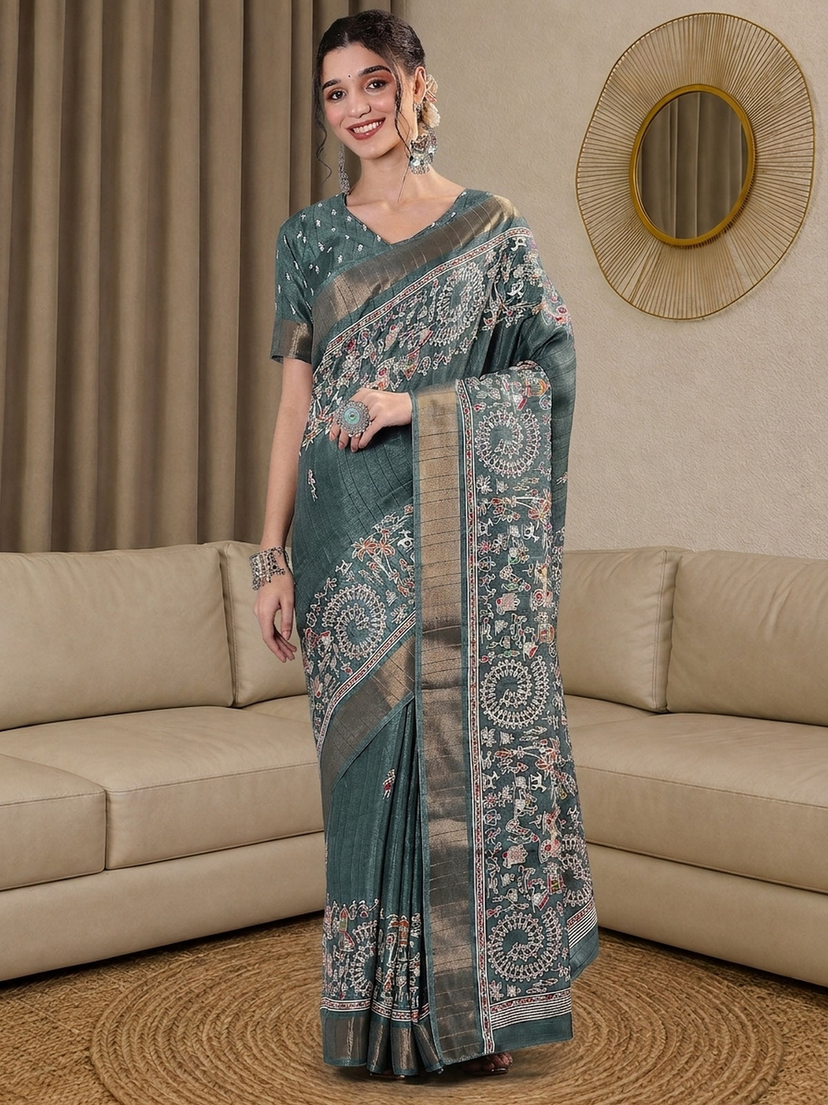 Woman wearing teal green silk blend saree with tribal folk-art motifs and teal green blouse