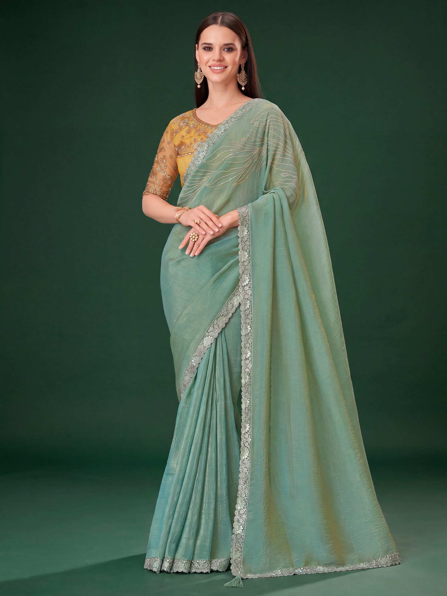 Woman wearing sea green satin silk saree with embroidered motif work and yellow blouse