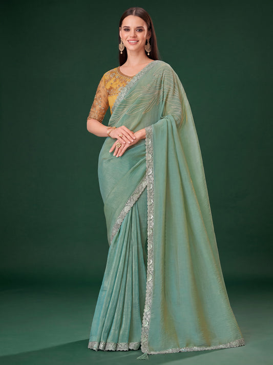 Woman wearing sea green satin silk saree with embroidered motif work and yellow blouse