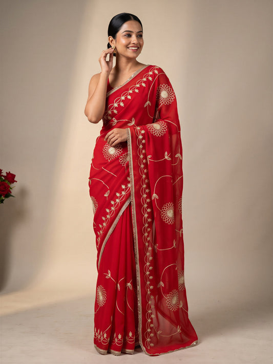 Woman wearing orange georgette saree with embroidered motif work and orange blouse