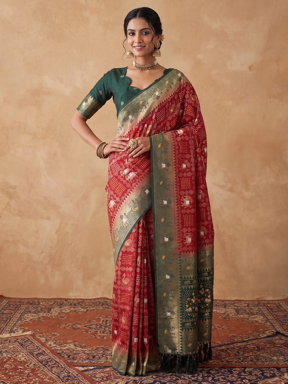 Woman wearing maroon dola silk saree with bandhani tie-dye dot work and green blouse