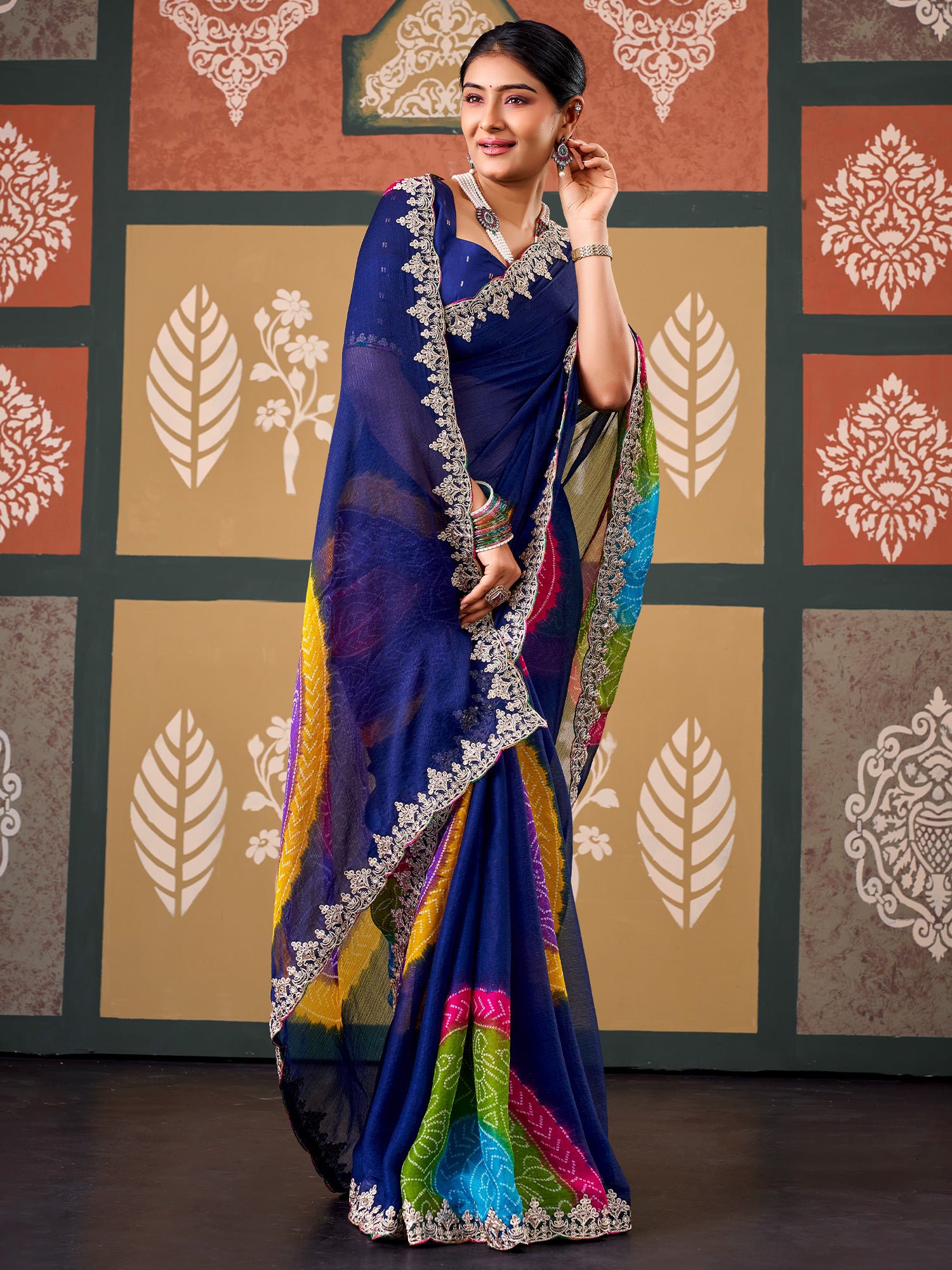 Woman wearing navy blue chiffon saree with bandhani tie-dye dot work and navy blue blouse