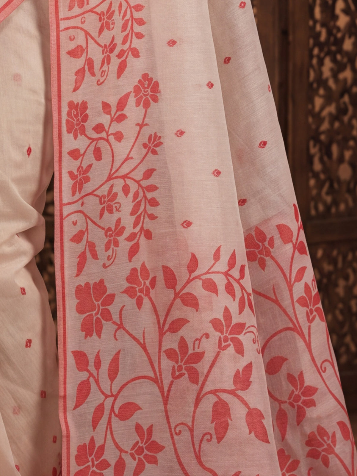 Pallu detail of white cotton linen saree showing all-over floral design and woven design border