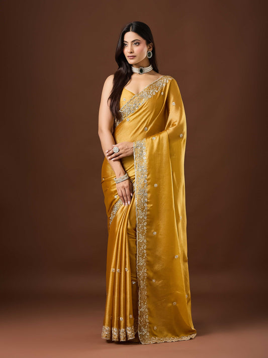Woman wearing mustard chinnon saree with embroidered motif work and mustard blouse