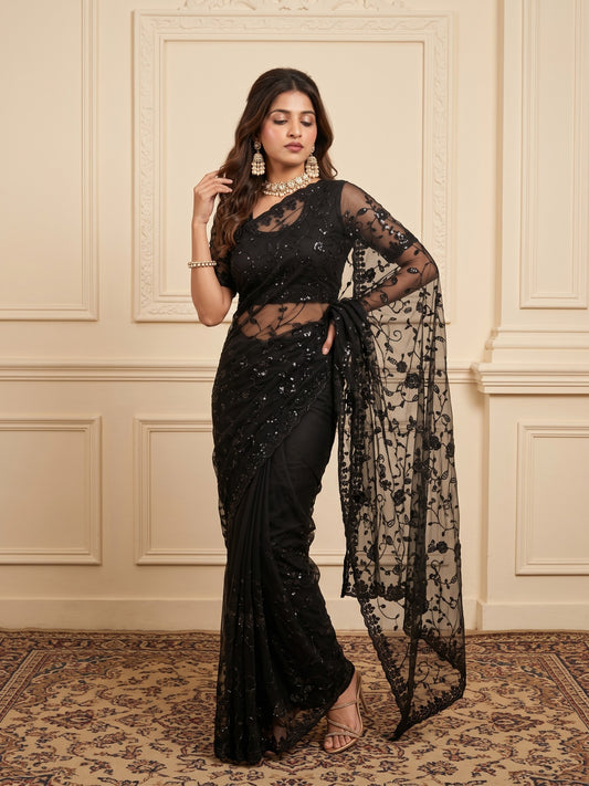 Woman wearing black georgette saree with ornamented surface design and black blouse