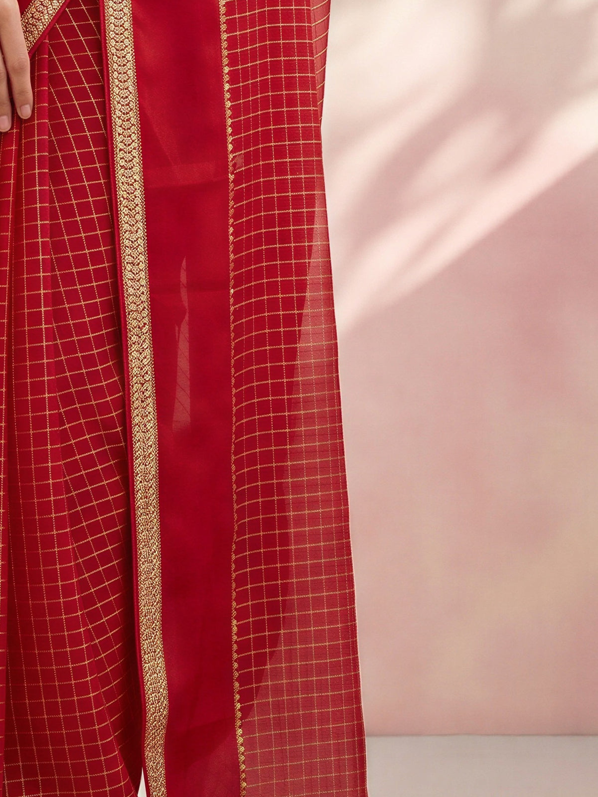 Pallu detail of red viscose saree showing checked pattern design and zari border