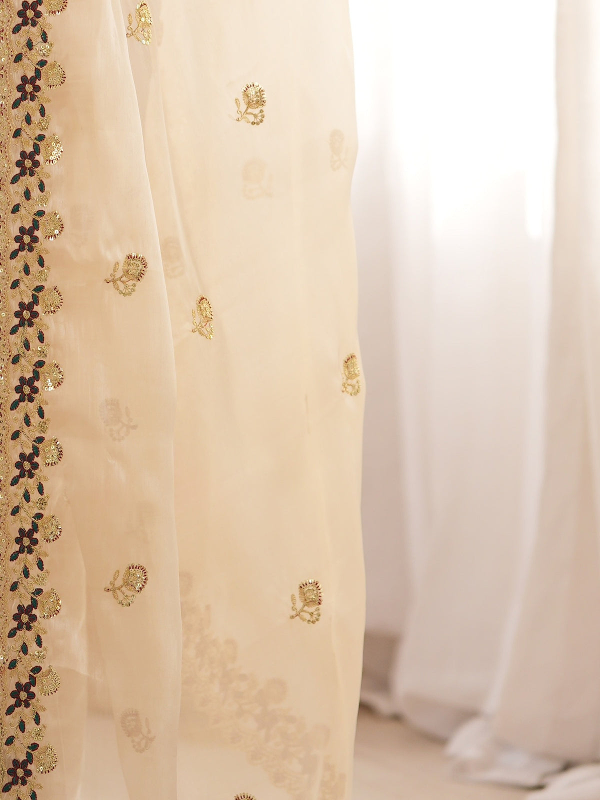 Pallu detail of beige satin saree showing ornamented surface design and embellished border